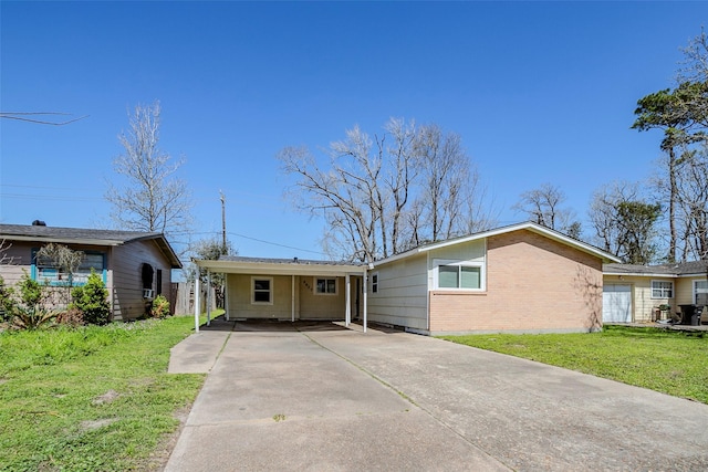 view of front of home with a front lawn, concrete driveway, and brick siding