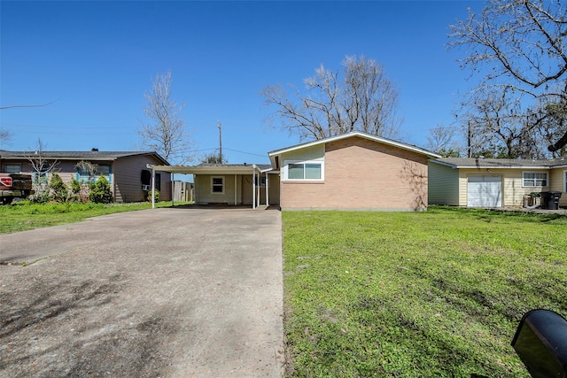 ranch-style home with brick siding, concrete driveway, and a front lawn