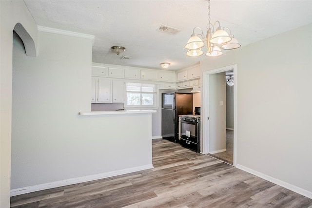 kitchen with visible vents, black appliances, wood finished floors, white cabinetry, and light countertops