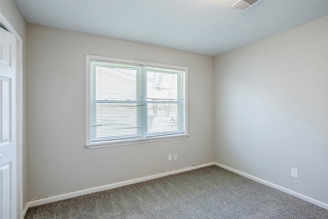 spare room featuring carpet flooring, baseboards, and visible vents