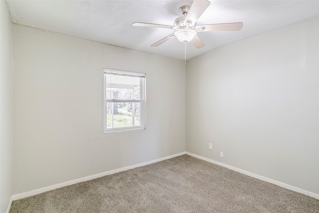 carpeted empty room featuring baseboards and ceiling fan