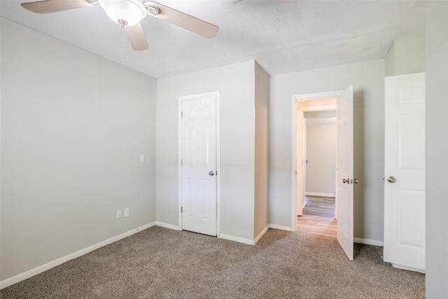 unfurnished bedroom featuring baseboards, carpet floors, and ceiling fan