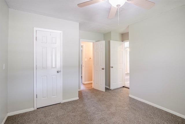 unfurnished bedroom with baseboards, carpet, and a ceiling fan