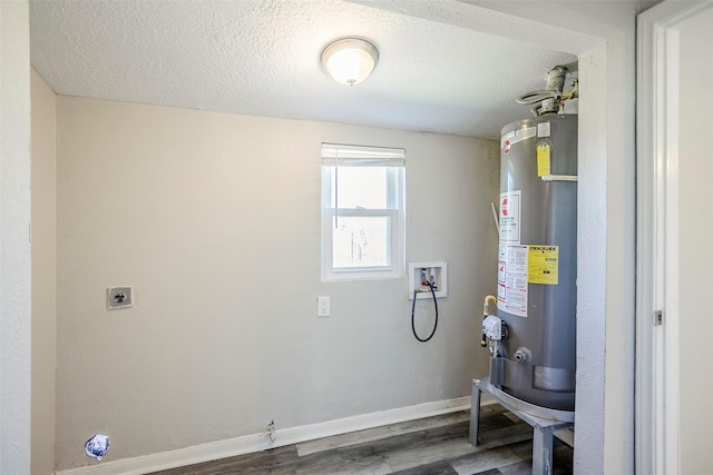 clothes washing area with baseboards, water heater, laundry area, hookup for a washing machine, and wood finished floors