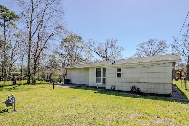 rear view of house featuring a yard and fence