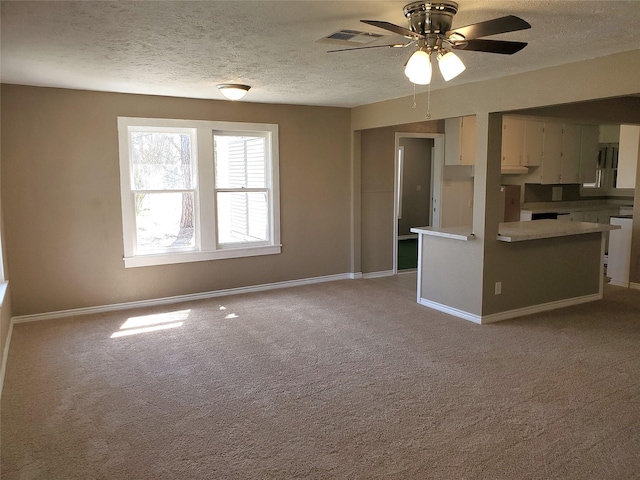 unfurnished living room featuring baseboards, light colored carpet, and a textured ceiling