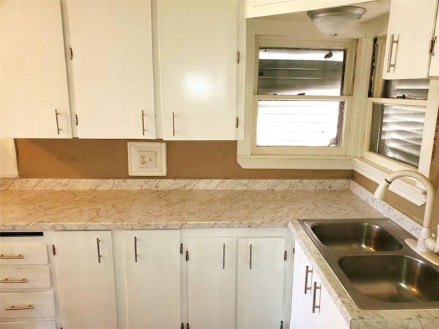 kitchen featuring a sink, light countertops, and white cabinetry