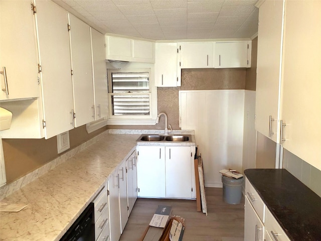 kitchen featuring white cabinetry, black dishwasher, light wood-style floors, and a sink