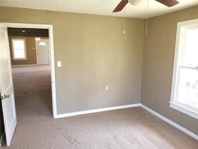 empty room with a ceiling fan, baseboards, and carpet floors