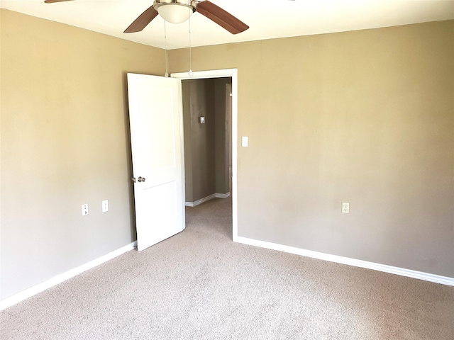 empty room featuring ceiling fan, baseboards, and carpet