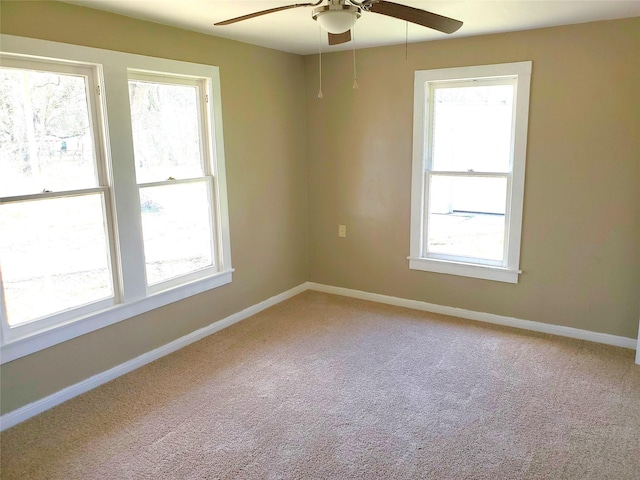 unfurnished room featuring baseboards, light colored carpet, and a ceiling fan