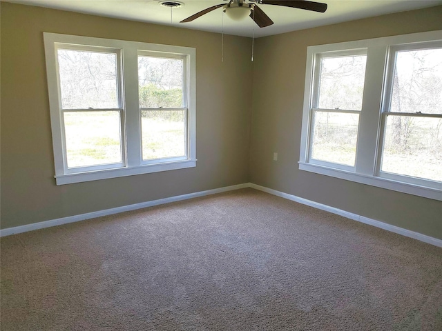 empty room featuring visible vents, carpet, baseboards, and ceiling fan