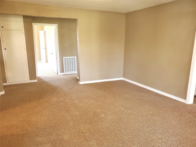 unfurnished room featuring visible vents, carpet floors, and baseboards