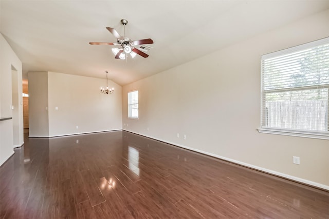 spare room featuring baseboards, ceiling fan with notable chandelier, wood finished floors, and vaulted ceiling