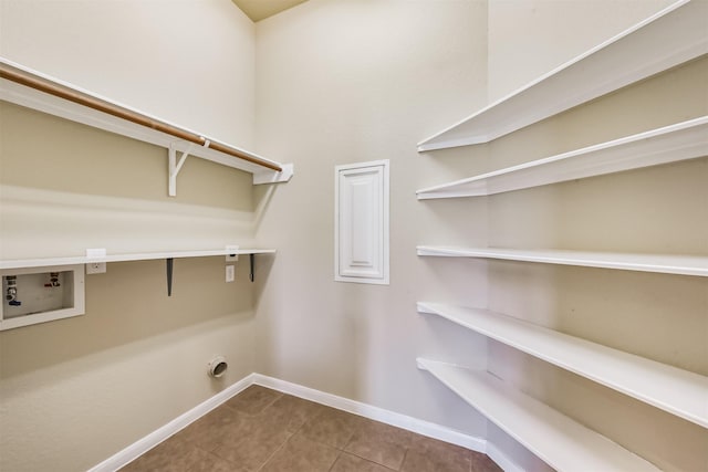 clothes washing area with baseboards, laundry area, electric dryer hookup, washer hookup, and tile patterned flooring