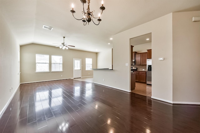 unfurnished living room with ceiling fan with notable chandelier, dark wood-style floors, visible vents, and baseboards