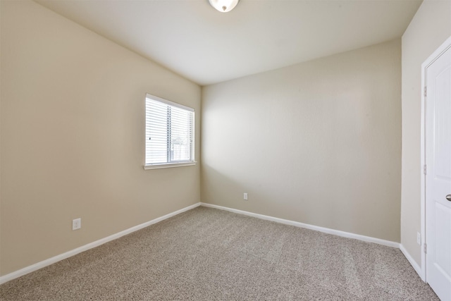 carpeted spare room featuring baseboards