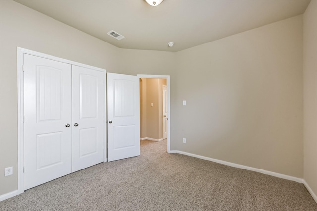 unfurnished bedroom featuring carpet, visible vents, a closet, and baseboards