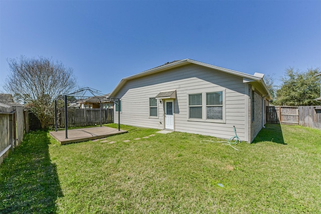 rear view of house with a gazebo, a lawn, brick siding, and a fenced backyard