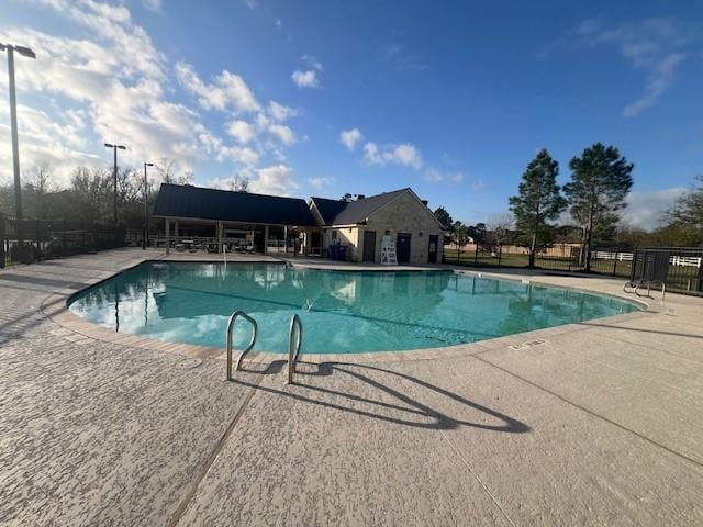 pool with a patio and fence