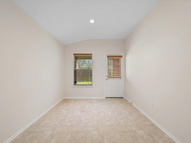 empty room featuring lofted ceiling, recessed lighting, and baseboards