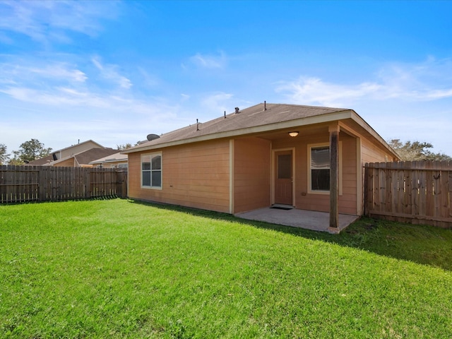 back of house with a patio, a fenced backyard, and a lawn