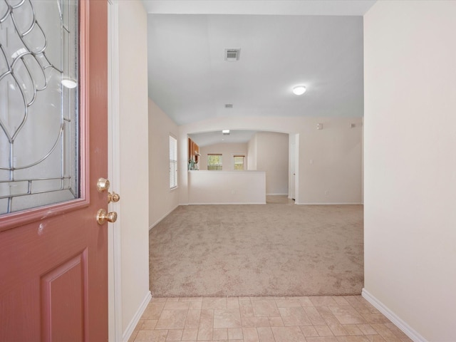 entryway featuring visible vents, light carpet, and baseboards