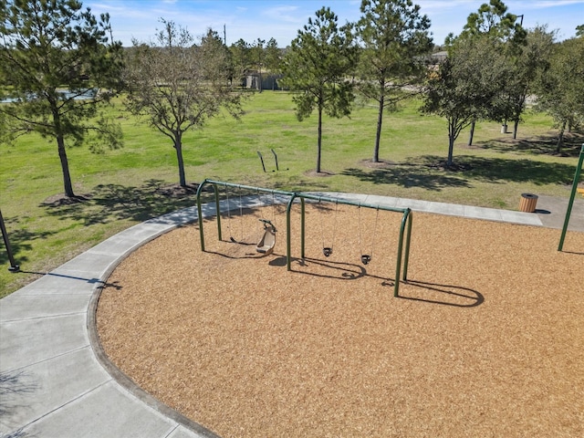 view of property's community with a lawn and playground community