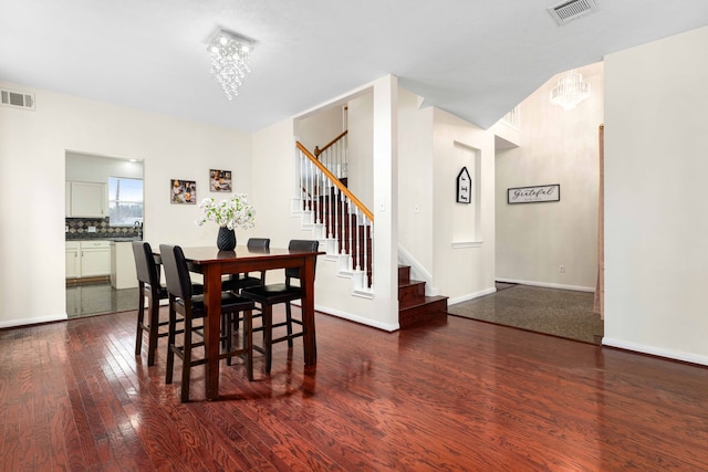 dining space with visible vents, an inviting chandelier, and stairs