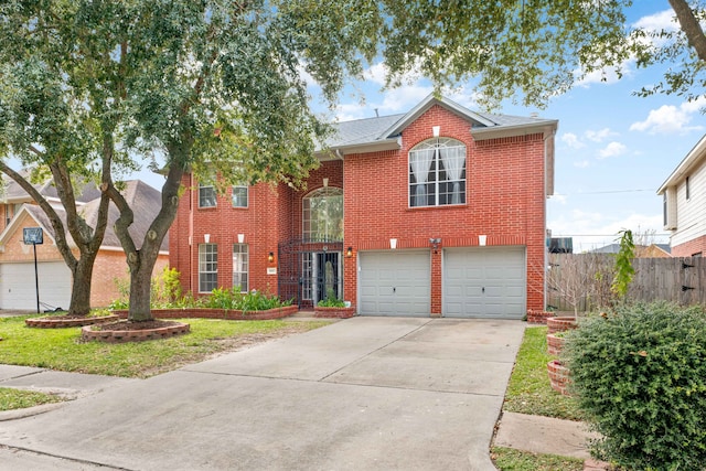 traditional home featuring brick siding, concrete driveway, an attached garage, and fence