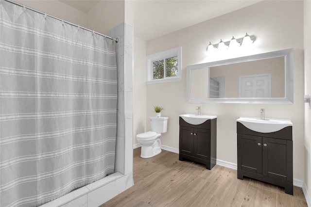 bathroom featuring vanity, a shower with curtain, wood finished floors, baseboards, and toilet