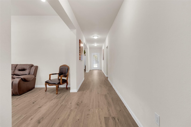 hall with light wood finished floors and baseboards