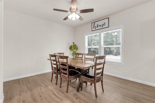 dining space featuring baseboards, light wood-style floors, and a ceiling fan