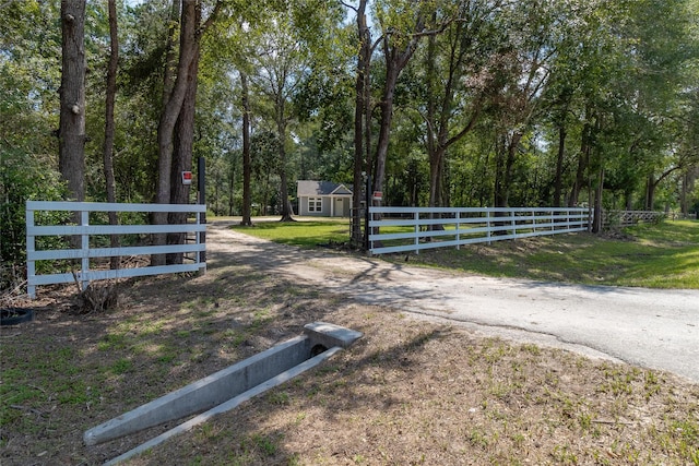 view of gate with a fenced front yard and a lawn