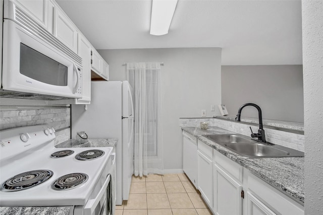 kitchen with white appliances, light tile patterned floors, a sink, decorative backsplash, and white cabinets