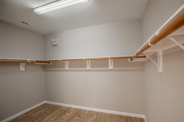 spacious closet featuring visible vents and light wood-type flooring