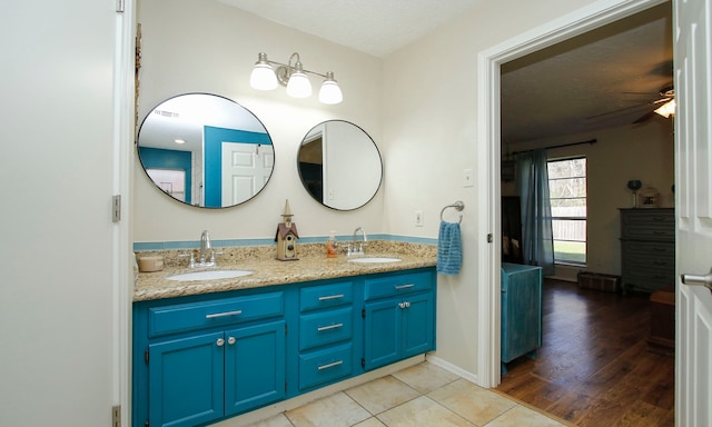 bathroom with double vanity, tile patterned flooring, a ceiling fan, and a sink