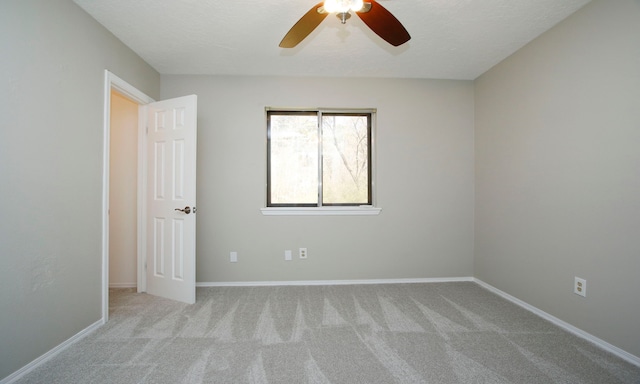 carpeted empty room featuring a ceiling fan, baseboards, and a textured ceiling