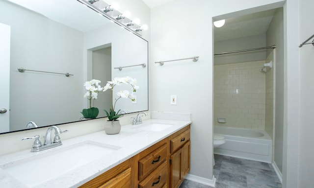 bathroom with double vanity, shower / washtub combination, toilet, and a sink