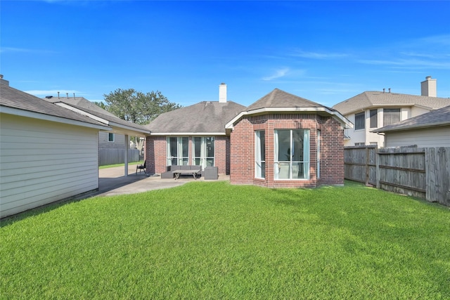 rear view of property featuring brick siding, fence private yard, and a patio