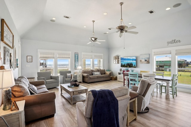 living room with recessed lighting, visible vents, light wood-style flooring, and high vaulted ceiling