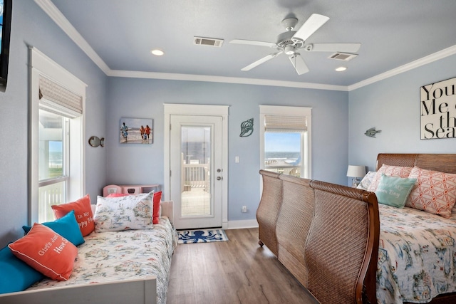 bedroom with visible vents, crown molding, baseboards, and wood finished floors