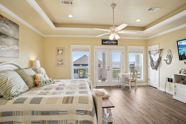 bedroom with french doors, a raised ceiling, visible vents, and access to outside