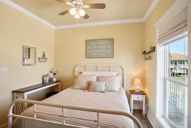 bedroom featuring a ceiling fan, wood finished floors, baseboards, and ornamental molding