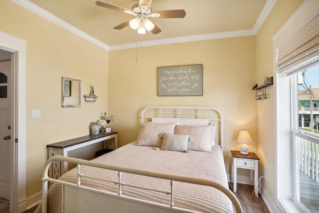 bedroom featuring a ceiling fan, crown molding, wood finished floors, and baseboards