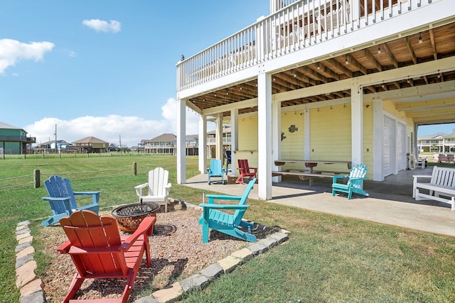 view of patio / terrace with fence, a garage, and an outdoor fire pit