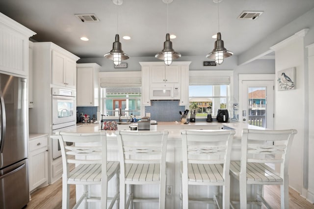 kitchen featuring white appliances, light countertops, and visible vents