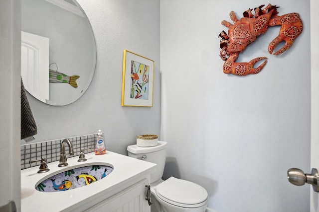 half bathroom with backsplash, toilet, and vanity