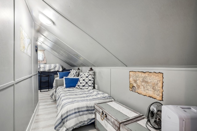 bedroom featuring lofted ceiling and wood finished floors