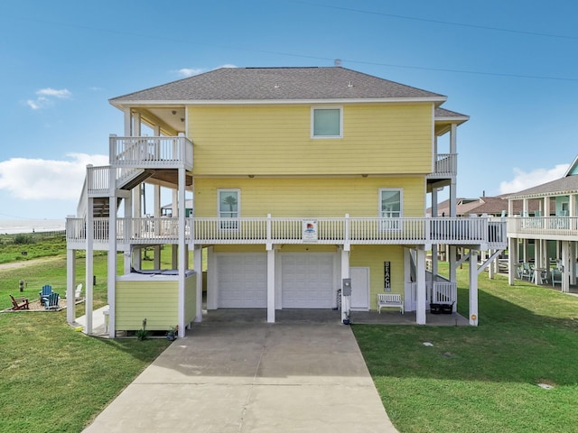 back of property featuring stairs, roof with shingles, a balcony, a yard, and driveway